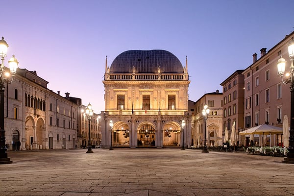 torischer Platz in Brescia mit Theatergebäude, Arkaden und Abendbeleuchtung