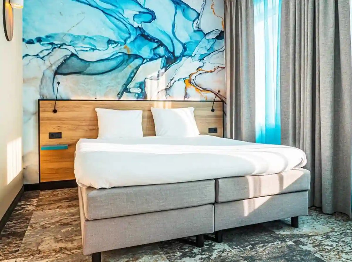 Modernes Doppelzimmer im Fletcher Hotel Scheveningen mit farbenfroher Wandgestaltung.