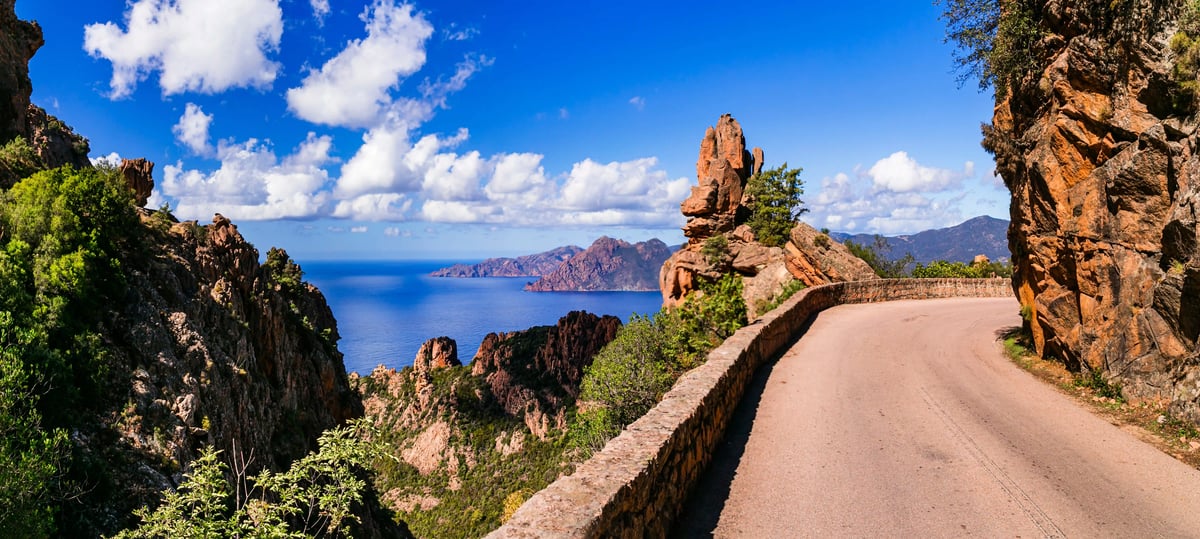 Küstenstrasse durch die roten Felsen der Calanche de Piana mit Blick aufs Meer