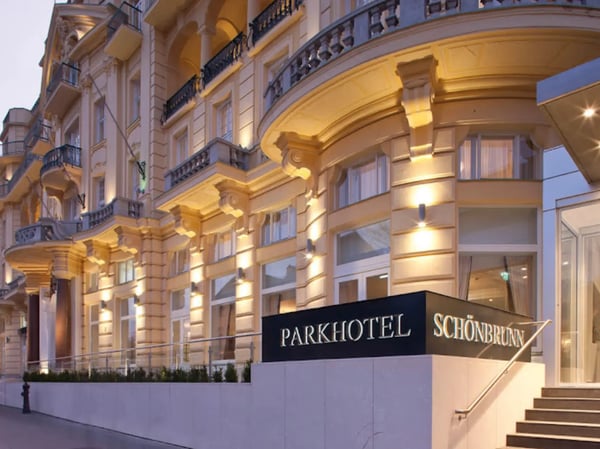 Fassade des Parkhotel Schönbrunn in Wien am Abend mit beleuchtetem Eingangsbereich