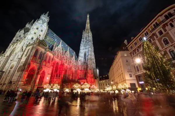 Stephansdom in Wien bei Nacht mit Weihnachtsbeleuchtung und vielen Menschen auf dem Platz