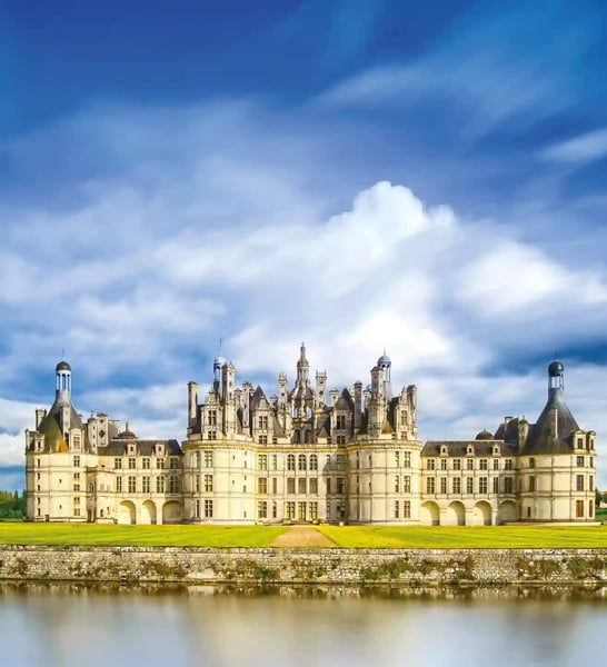 Schloss Chambord mit markanter Dachlandschaft vor blauem Himmel und Wassergraben