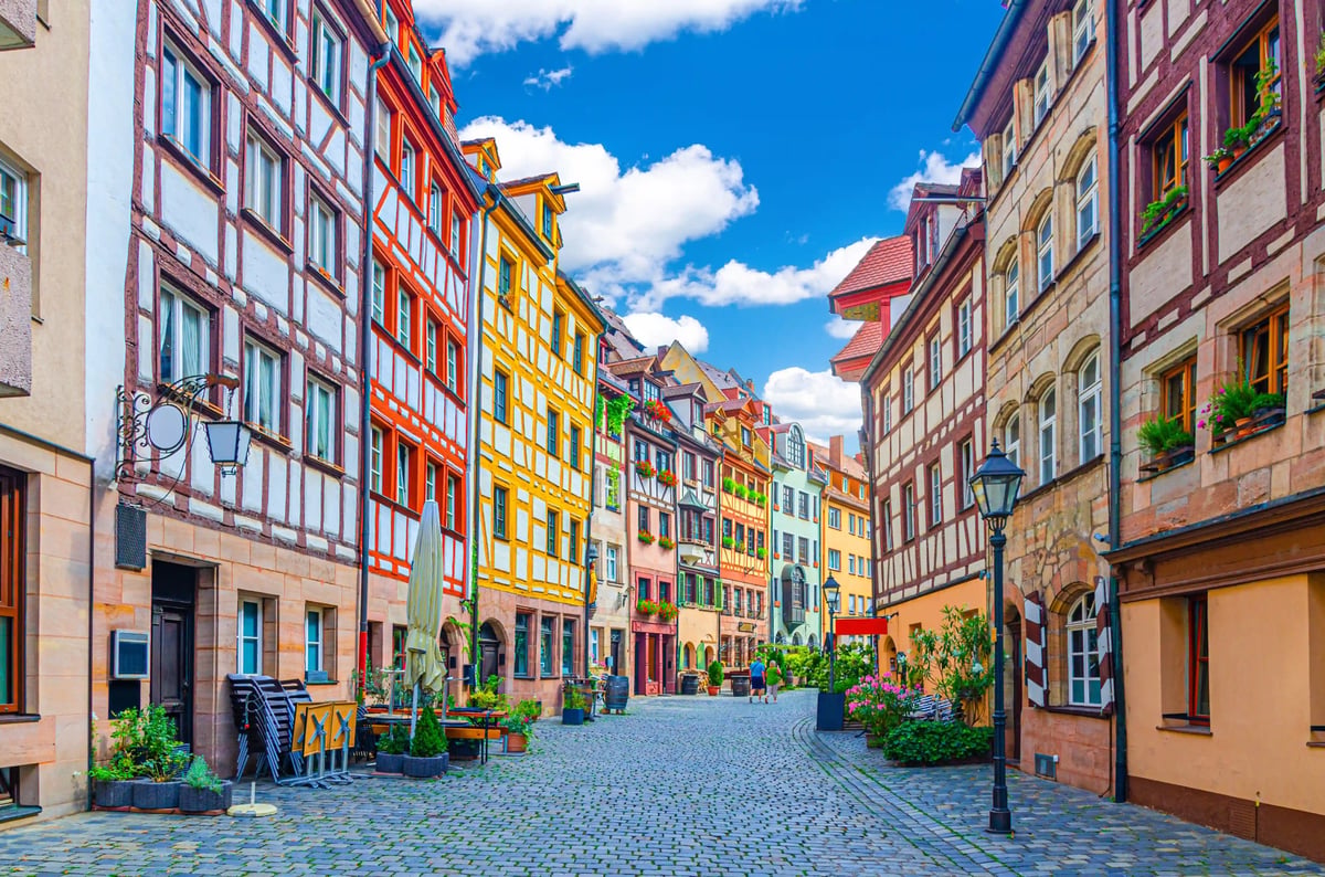 Kopfsteinpflastergasse mit farbenfrohen Fachwerkhäusern in einer historischen Altstadt bei Tageslicht