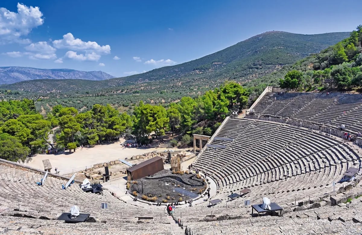 Antikes Theater von Epidaurus mit weitläufiger Berglandschaft im Hintergrund.
