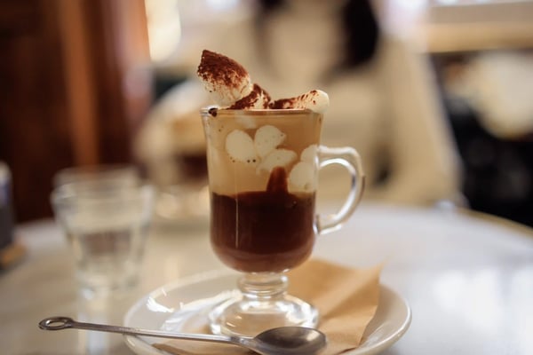 Glas mit Bicerin bestehend aus Kaffee, Schokolade und Sahne auf einer Untertasse