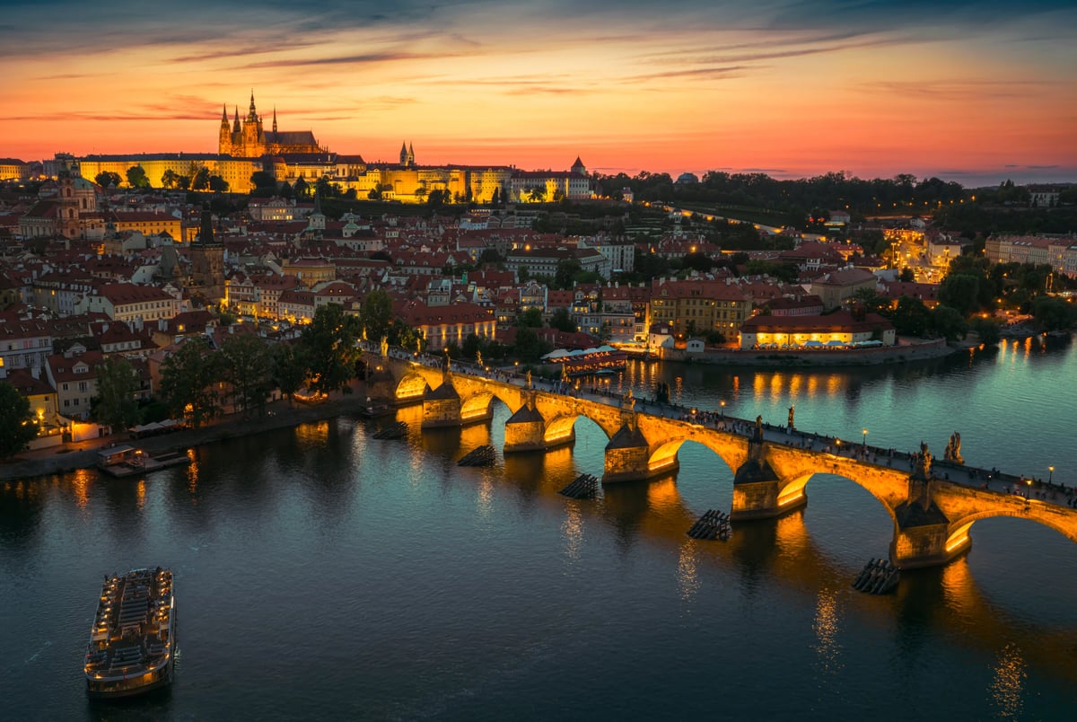 Blick über Prag mit Karlsbrücke, Moldau und Prager Burg bei Sonnenuntergang