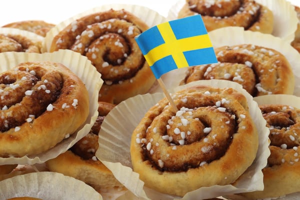 Frisch gebackene Zimtschnecken mit Hagelzucker, dekoriert mit kleiner schwedischer Flagge