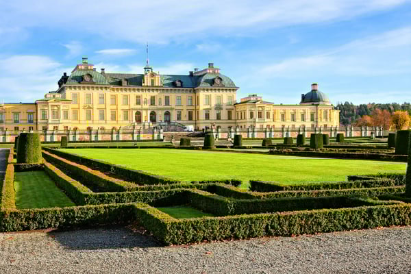 Schloss Drottningholm mit gepflegtem Barockgarten und symmetrischen Heckenanlagen bei sonnigem Wetter