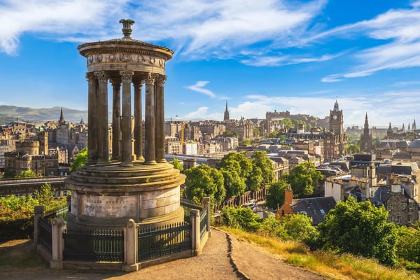 Blick vom Calton Hill auf Edinburgh mit klassischem Denkmal, Altstadt und grünen Parkanlagen