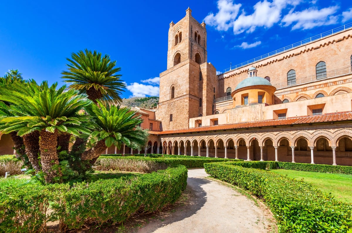 Kreuzgang der Kathedrale von Monreale mit Arkaden, Garten und Palmen