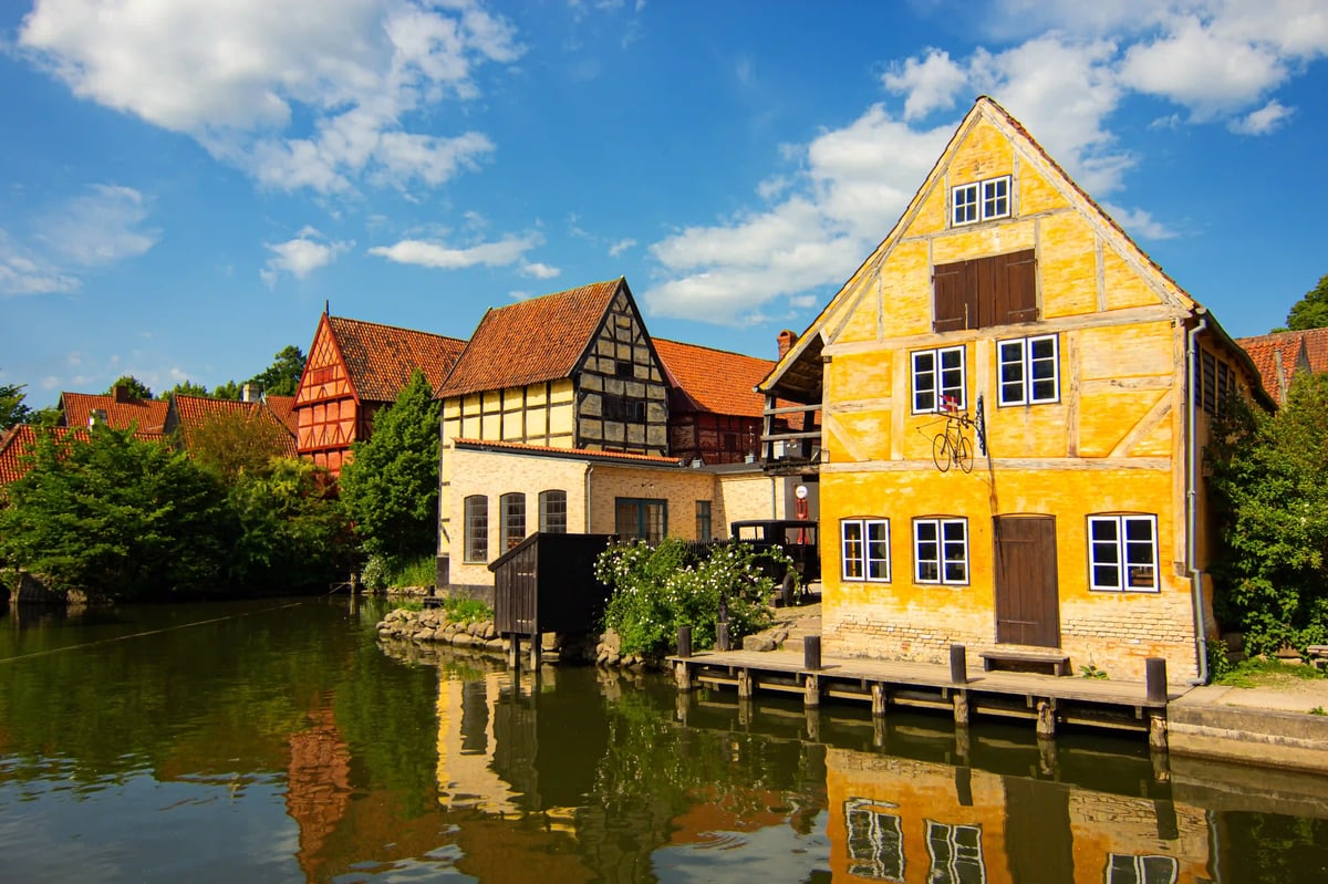 Kopfsteinpflastergasse mit farbigen historischen Häusern im Freilichtmuseum Den Gamle By in Aarhus
