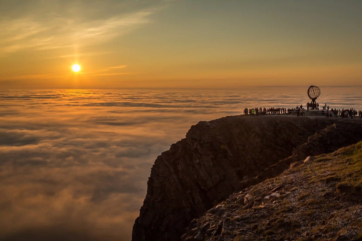 Sonnenuntergang am Nordkap mit Aussichtsplattform, Globusdenkmal und Besucherinnen und Besuchern