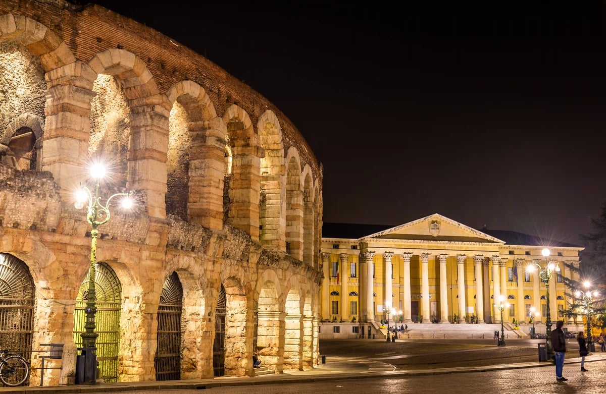 Detailansicht der Arena di Verona bei Nacht mit angrenzendem klassizistischem Gebäude