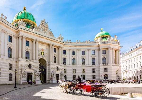 Hofburg Wien mit grünen Kuppeln und Pferdekutschen auf dem Michaelerplatz