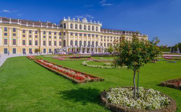 Schloss Schönbrunn mit barocker Fassade und gepflegtem Schlossgarten bei blauem Himmel