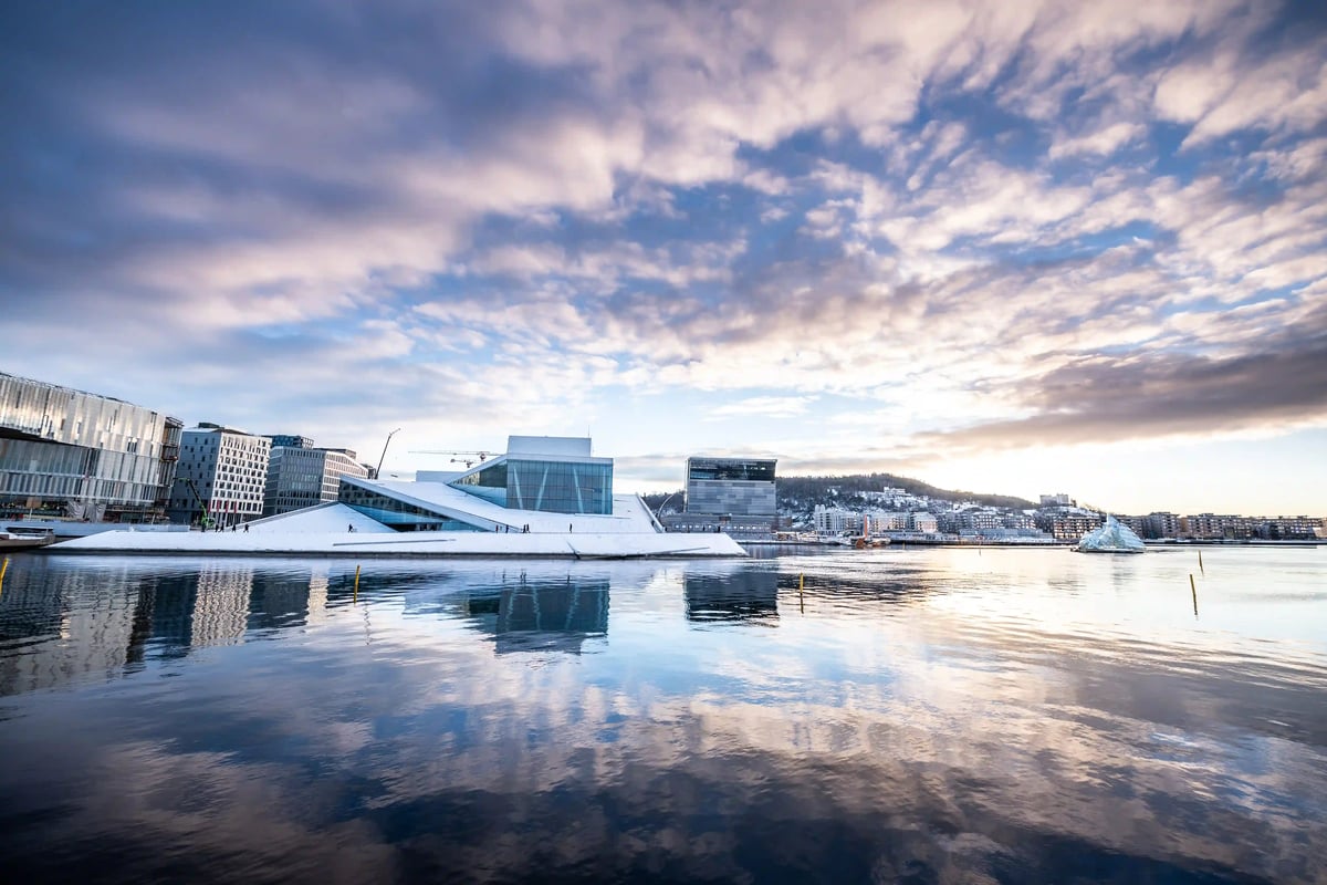 Modernes Opernhaus in Oslo am Fjord mit Spiegelung im Wasser.