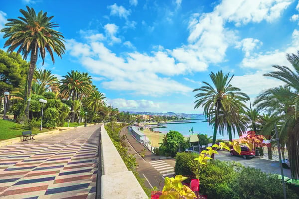 Promenade bordée de palmiers à San Remo avec vue sur la mer, plage et chemin piéton