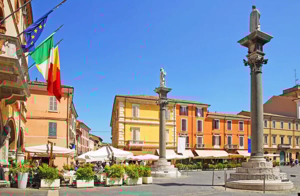 Historischer Platz in Ravenna mit Säulen, Cafés, Flaggen und farbigen Gebäuden