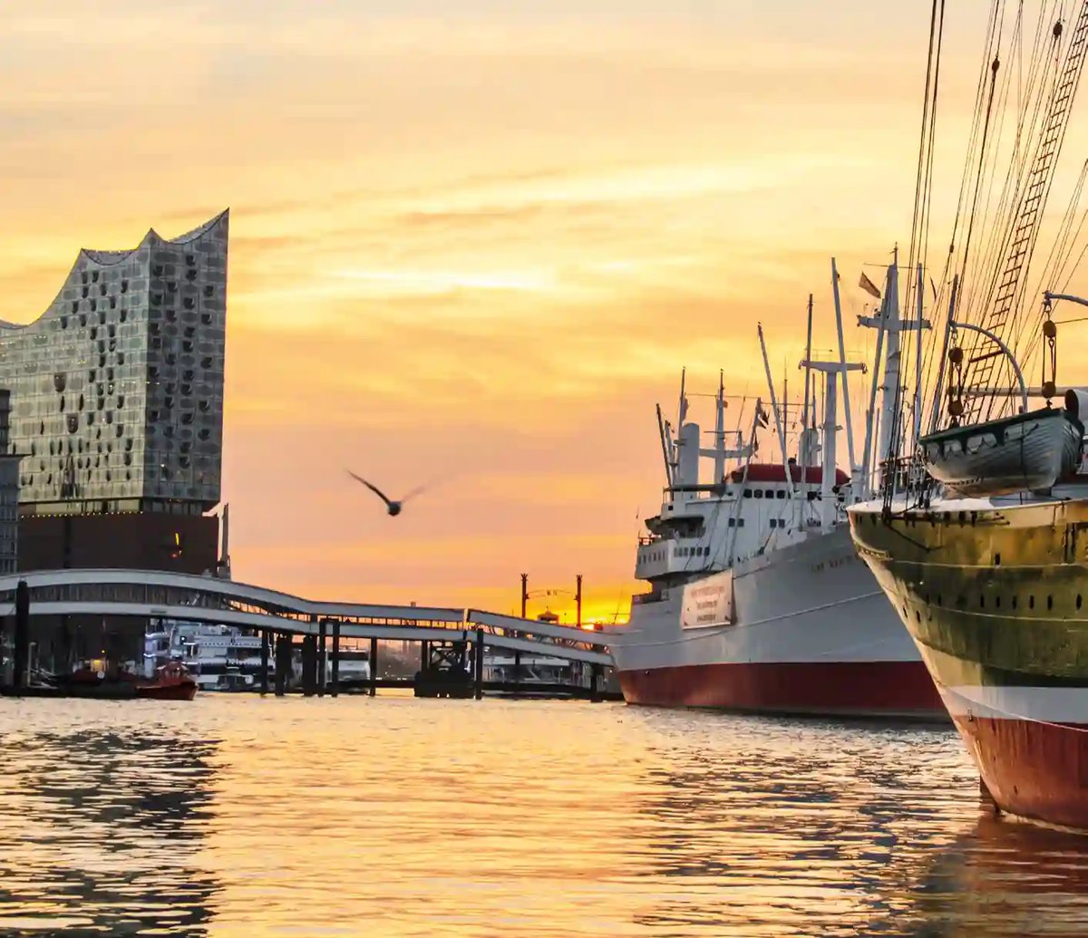 Elbphilharmonie und historische Schiffe im Hamburger Hafen bei goldenem Sonnenuntergang