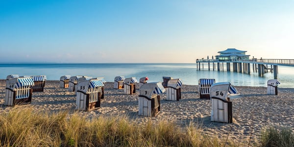 Strandkörbe am Sandstrand von Timmendorfer Strand mit Seebrücke und ruhiger Ostsee