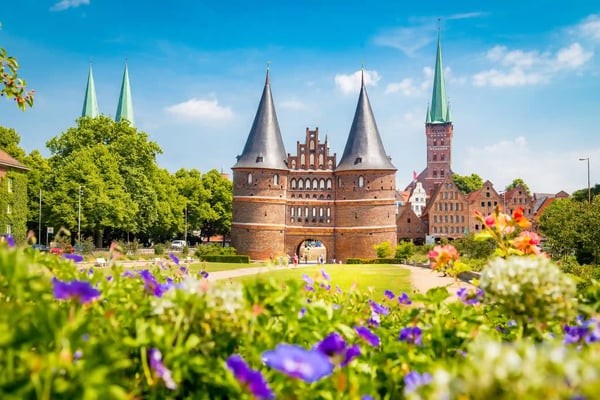 Holstentor und historische Altstadt von Lübeck mit Blumen im Vordergrund
