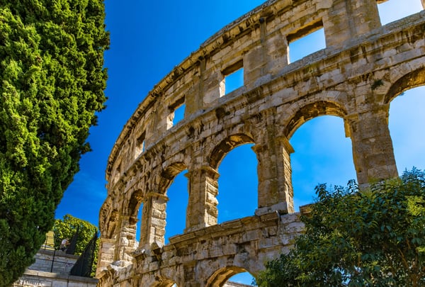 Amphithéâtre romain de Pula avec arches en pierre sous un ciel bleu