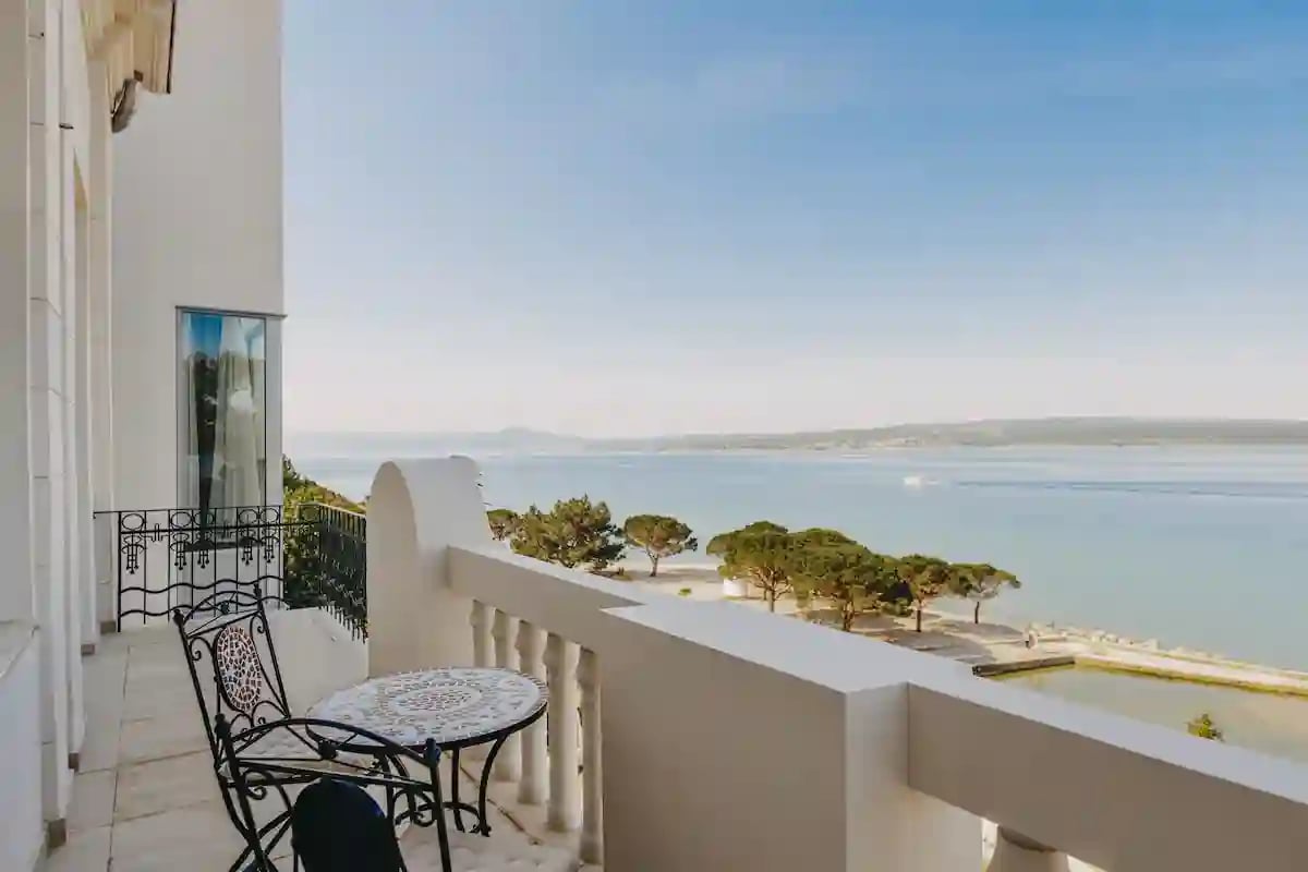 Balkon mit Tisch und Stühlen im Hotel Miramare mit Blick auf das Meer und die Küste