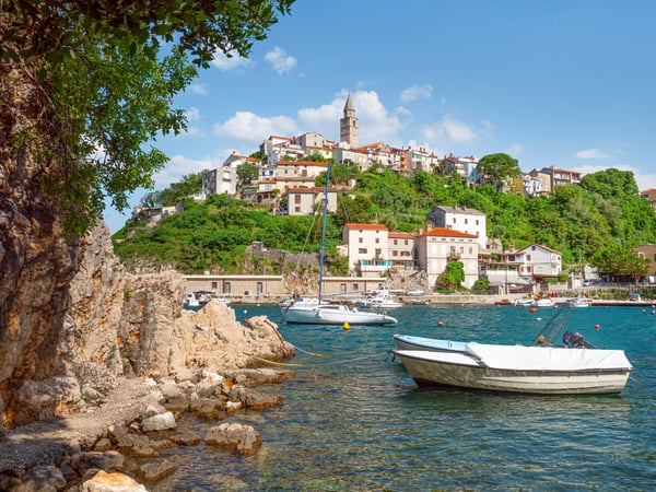 Küstendorf Vrbnik auf einem Hügel mit Booten im Hafen und Blick auf das Meer