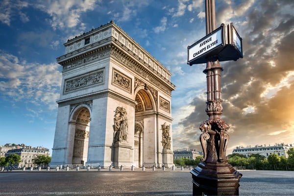 Triumphbogen Arc de Triomphe in Paris mit Strassenschild Avenue des Champs Elysees bei teilweise bewölktem Himmel