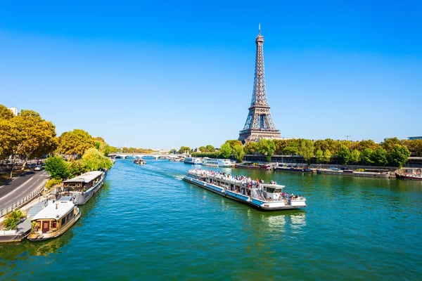 Seine in Paris mit Ausflugsbooten und Blick auf den Eiffelturm bei blauem Himmel