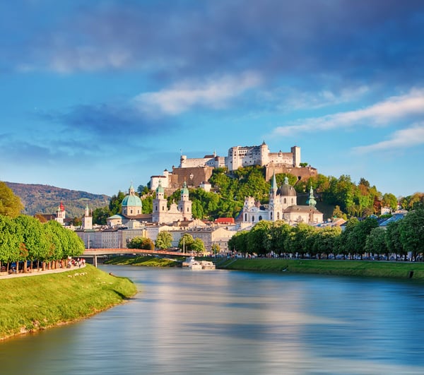 Blick auf Salzburg mit Festung Hohensalzburg und Fluss im Vordergrund