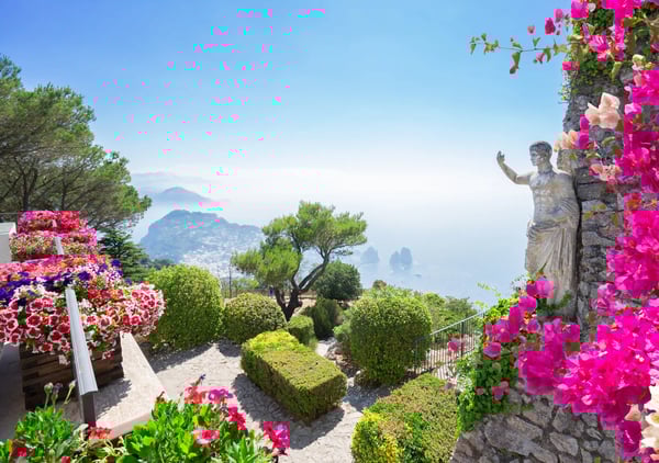 Garten mit bunten Blumen, Statue und weitem Blick auf das Meer und die Kueste von Capri