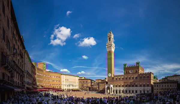 Belebter Piazza del Campo in Siena mit historischem Rathaus Torre del Mangia und vielen Besuchern
