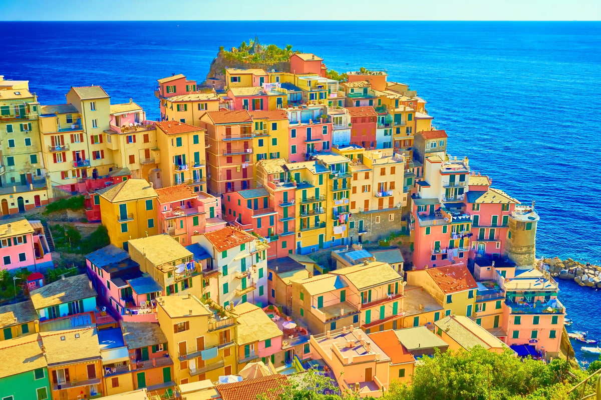 Farbenfrohe Häuser der Cinque Terre dicht aneinander gebaut auf einem Felsen über dem Meer