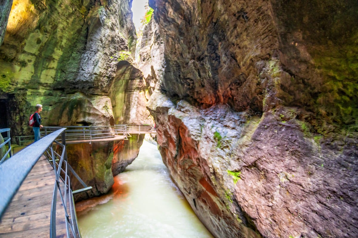 Holzsteg führt durch enge Aareschlucht mit hohen Felswänden und fliessendem Wasser