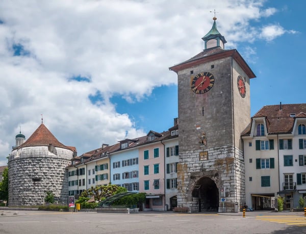 Historischer Stadtturm und Gebäude der Altstadt von Solothurn bei blauem Himmel