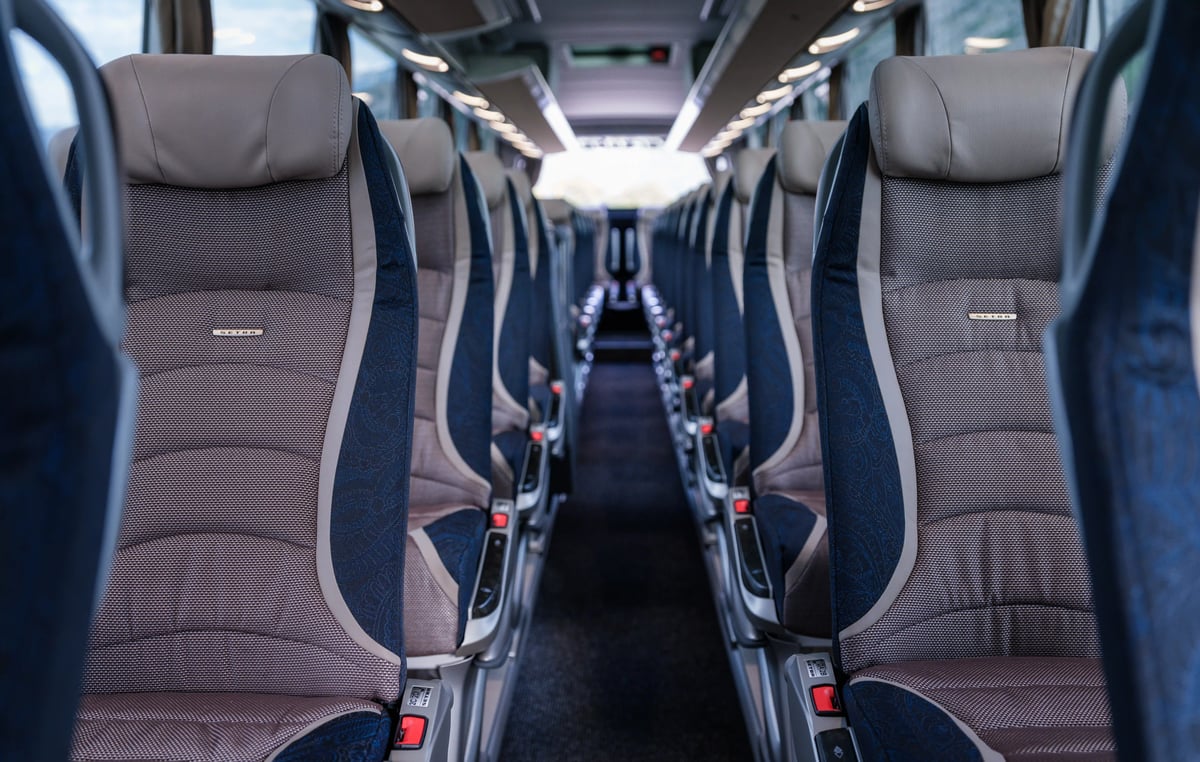 Vue intérieure d’un autocar confortable avec sièges spacieux, allée centrale et éclairage indirect