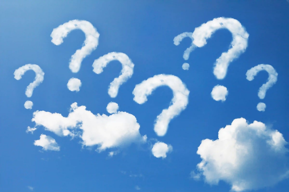 Plusieurs points d’interrogation formés par des nuages blancs dans un ciel bleu symbolisant la curiosité et la surprise
