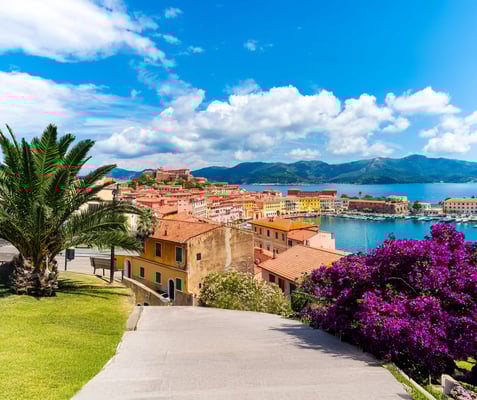 Blick auf Marciana Marina mit bunten Häusern, Hafen und Mittelmeer