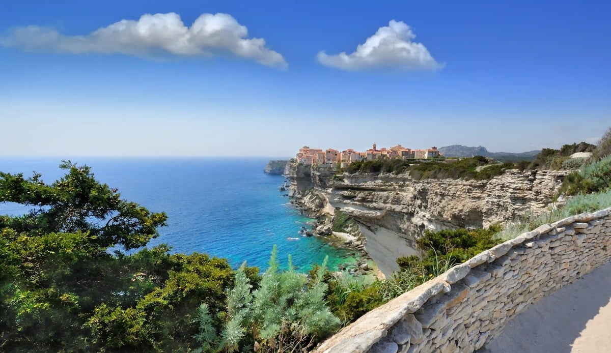 Bonifacio en Corse avec vieille ville perchée sur des falaises blanches au-dessus de la mer turquoise