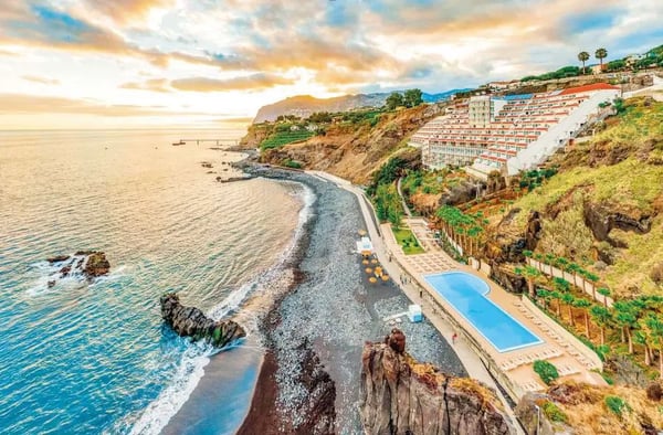 Hotelanlage an der Küste von Funchal mit Pool, Strand und Terrassen am Meer