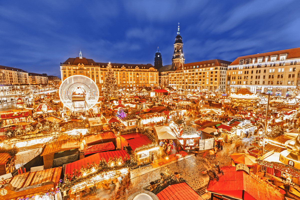 Festlich beleuchteter Weihnachtsmarkt mit Weihnachtsbaum und Riesenrad auf dem Altmarkt.