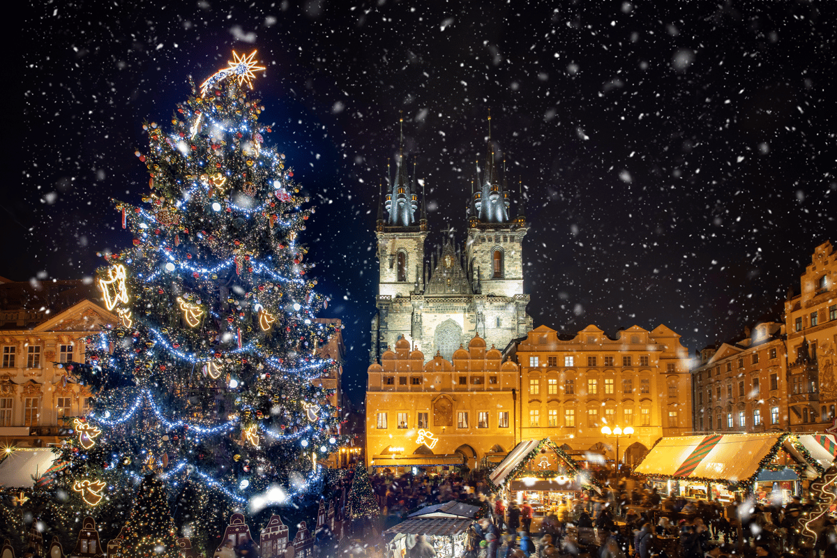 Grosser geschmückter Weihnachtsbaum vor der Teynkirche am Altstädter Ring bei Schneefall.