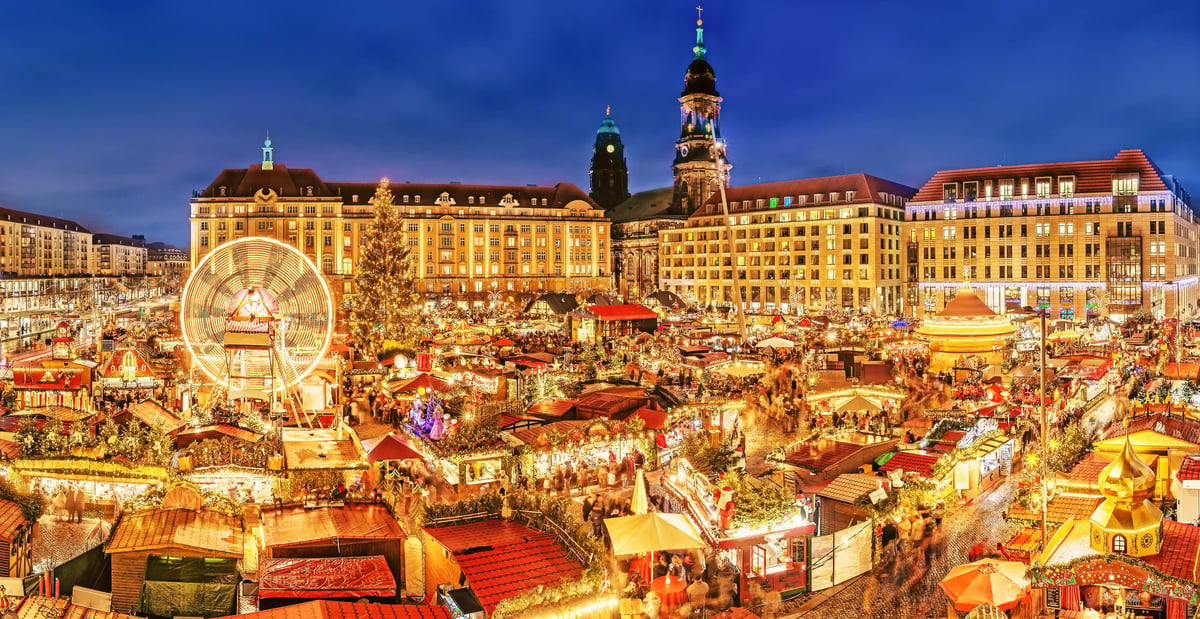 Grosser Weihnachtsmarkt in Dresden mit festlicher Beleuchtung und Stadtkulisse