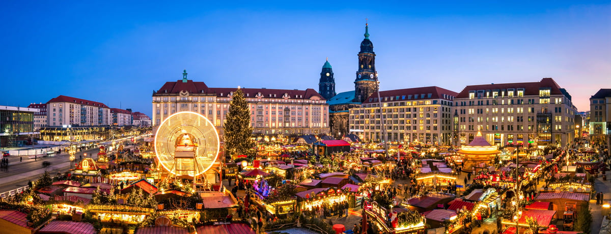Grosser Weihnachtsmarkt in Dresden mit Riesenrad, Buden und Lichtern bei Nacht