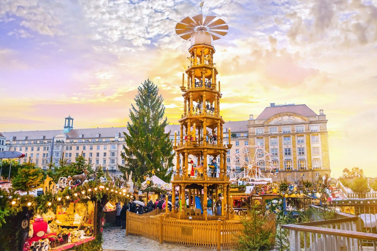 Grosse Weihnachtspyramide auf einem Platz mit Marktständen und Gebäuden