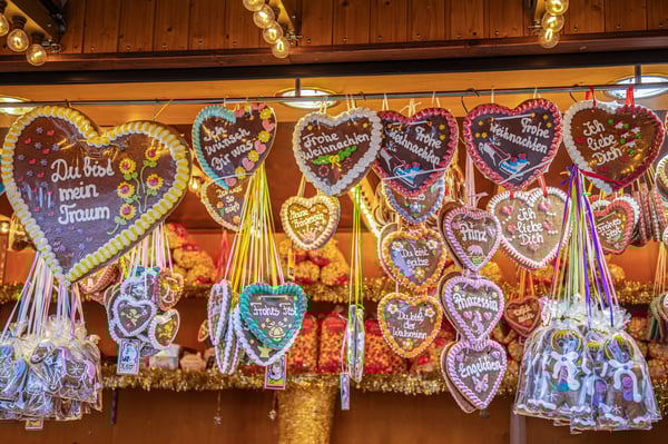 Lebkuchenherzen mit bunten Verzierungen und Sprüchen hängen an einem Marktstand
