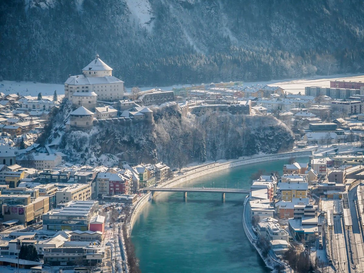 Festung Kufstein über dem Inn mit verschneiter Altstadt und Winterlandschaft.