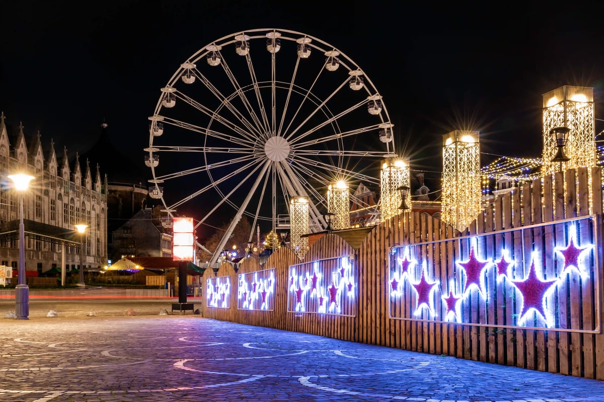 Beleuchteter Weihnachtsmarkt in Lüttich mit Riesenrad und festlicher Dekoration bei Nacht