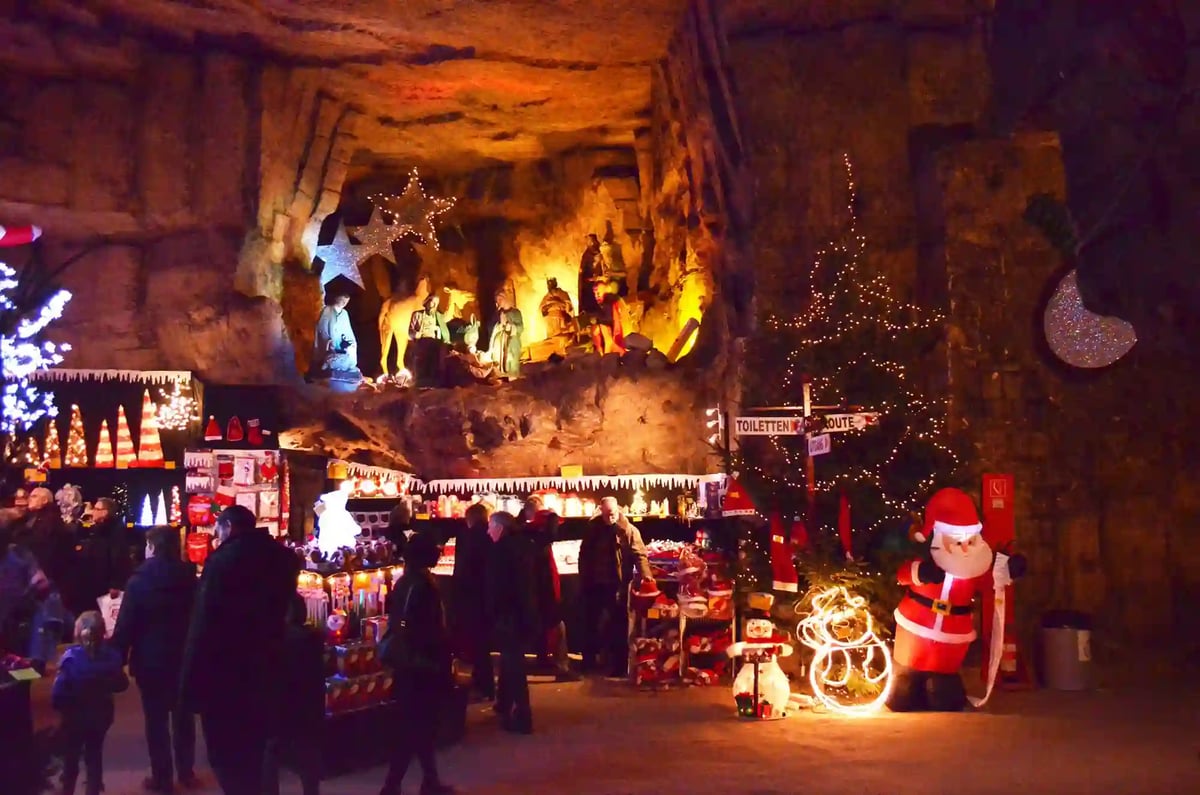 Weihnachtsmarkt in den Valkenburger Grotten mit Verkaufsständen, Krippenszene und festlicher Beleuchtung